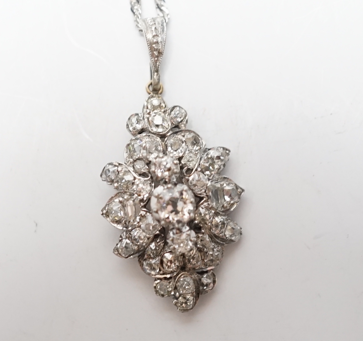 A white metal and diamond cluster set lozenge shape pendant, overall 38mm, on a modern 9ct white gold, chain, 45cm, gross weight 5.8 grams.